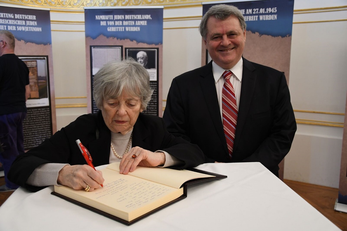 Хельга Кински оставляет запись в Книге отзывов; справа – Илья Альтман